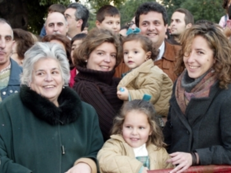 Grupo de personas sonrientes en un evento público, rodeados por otros espectadores.
