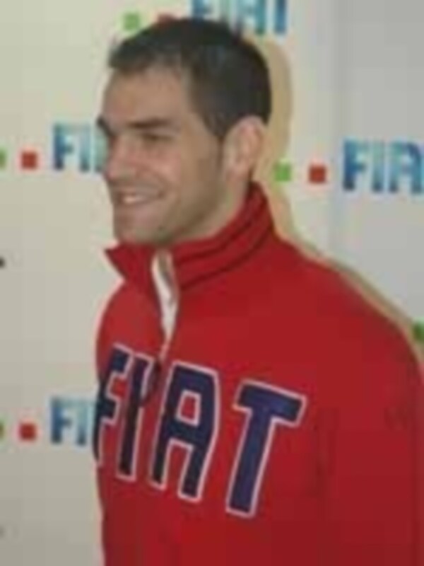 Un hombre con una camiseta roja y azul con la palabra 'Fiat' en la parte superior.