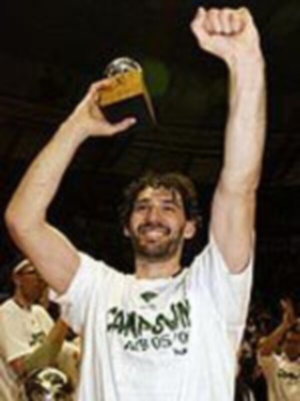 Un hombre sostiene una copa mientras levanta la mano izquierda, celebrando con un ambiente festivo y diversión.