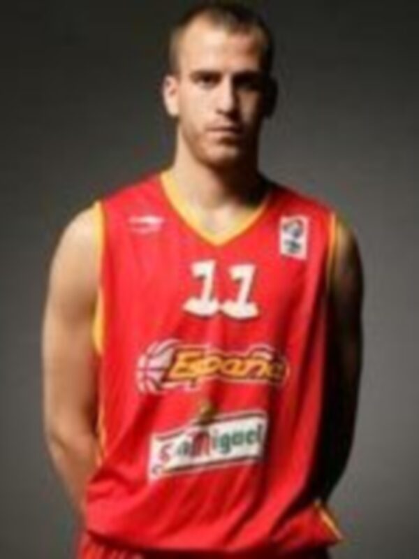 Un hombre vestido con una camiseta roja y el número 11, posando para la foto.