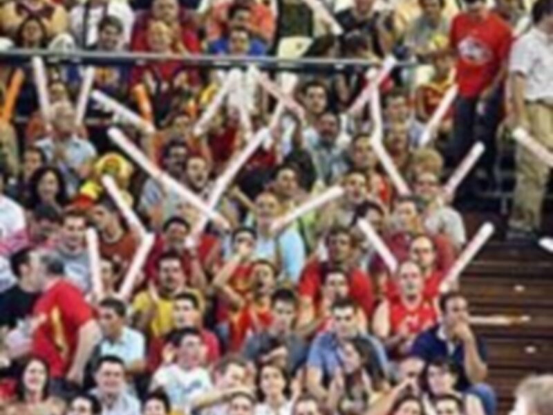 Un grupo de personas en una tribuna, con manos levantadas y gestos celebrativos. La imagen sugiere un evento deportivo emocionante, posiblemente un partido de fútbol.