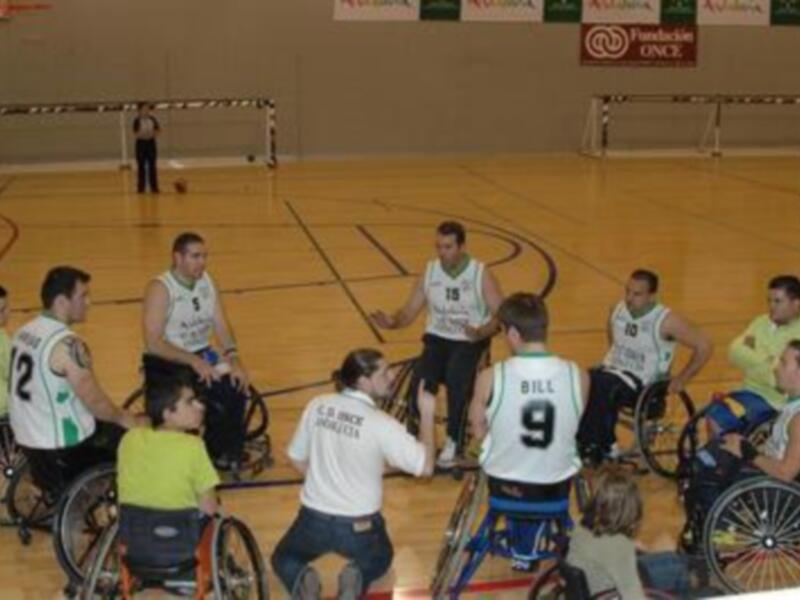 Equipo de baloncesto en silla de ruedas en una reunión táctica en el campo de juego.