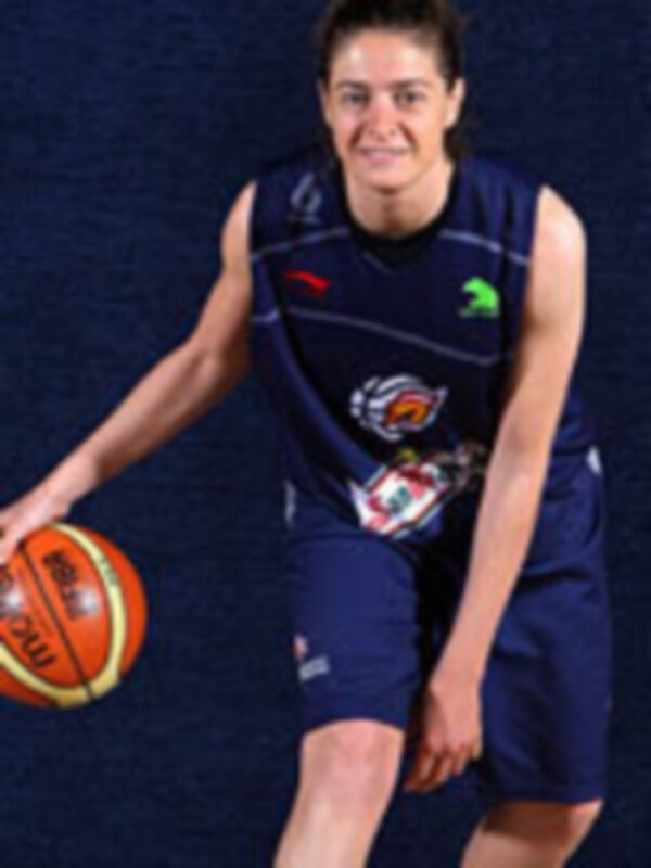 Joven jugador de baloncesto en uniforme azul y rojo, sosteniendo una pelota de baloncesto.