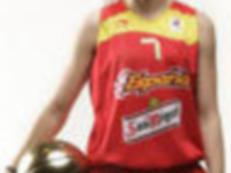 Una mujer vestida con una camiseta de baloncesto roja y amarilla, posando con un balón en la mano.