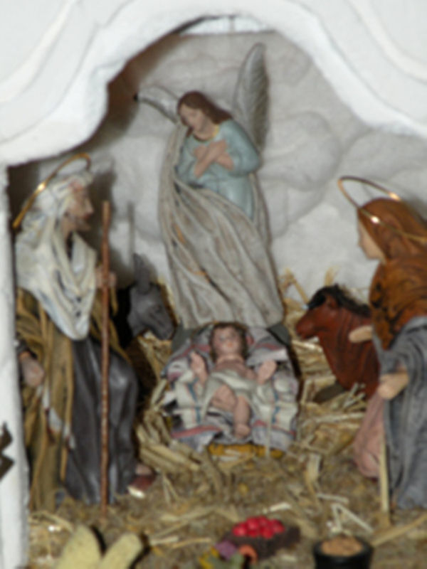 Representación artística de la Natividad con figuras religiosas en un establo