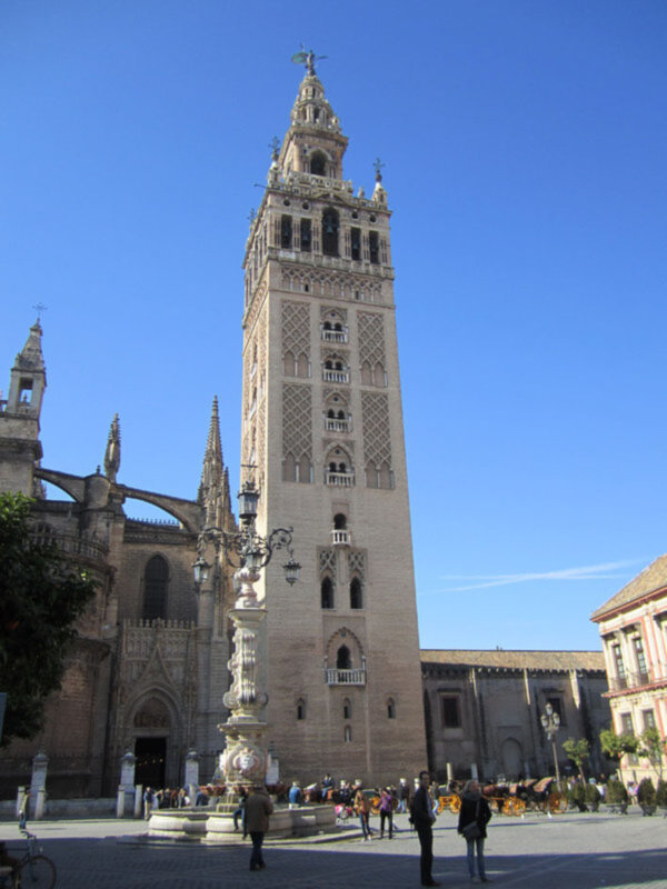 La Giralda, la torre de la Catedral de Sevilla, España, bajo un cielo azul claro.