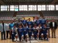 Equipo de baloncesto celebrando una victoria en un gimnasio con medallas.