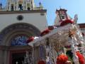 Festival religioso en una iglesia con altares decorados y gente celebrando.