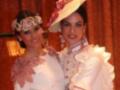 Dos mujeres vestidas con trajes tradicionales posan para la foto, uno con un sombrero y el otro con una corona.