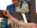 Recreación histórica de la crucifixión de Jesús, con actores vestidos con túnicas y mantas tradicionales, mostrando la pasión y sufrimiento.