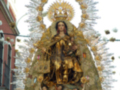 Procesión de la Virgen con ornamentos dorados y arco de flores en el cielo.