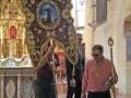 En una iglesia con altares dorados y vitrales, tres personas tocan instrumentos musicales. La imagen muestra un músico tocando una guitarra eléctrica, otro con una flauta y el tercero con un instrumento de cuerda. La escena transmite una atmósfera de concierto religioso o cultural dentro del templo.