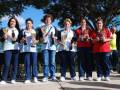 Equipo femenino de tenis posando con trofeos, celebrando un éxito deportivo.