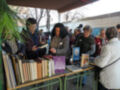 Personas comprando libros en un mercado de libros al aire libre.