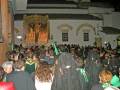 Fiesta religiosa con procesión y multitud en una iglesia histórica.
