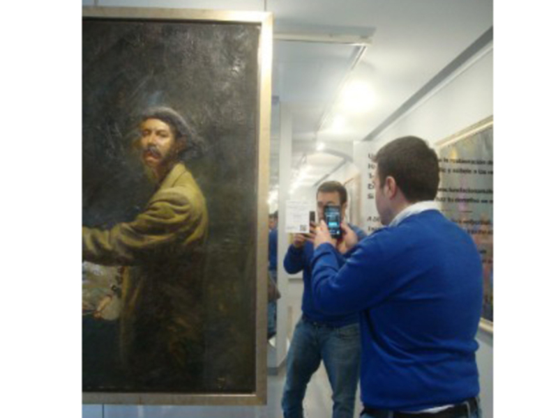 Visitantes toman fotos de un retrato histórico en un museo.