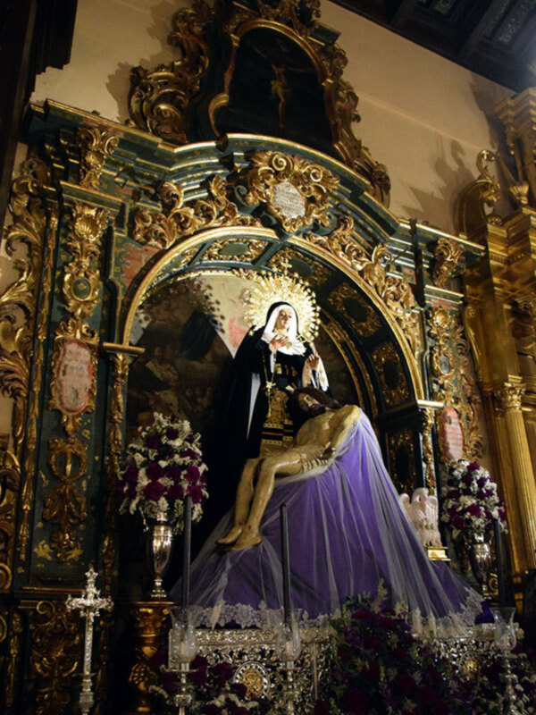 Altar con imagen de la Virgen de los Dolores, vestida de luto, en un entorno barroco y ornamental.