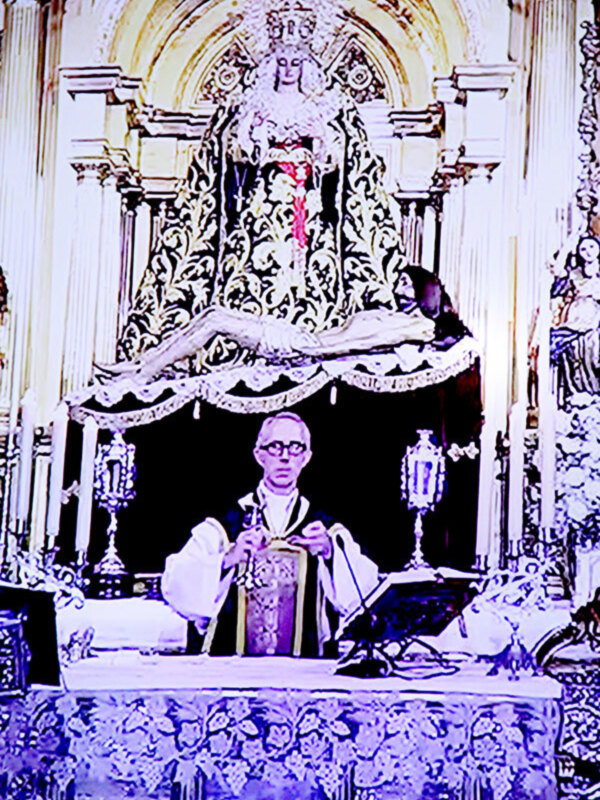 Retablo de la Virgen de la Candelaria en un templo católico, con un sacerdote en el altar.