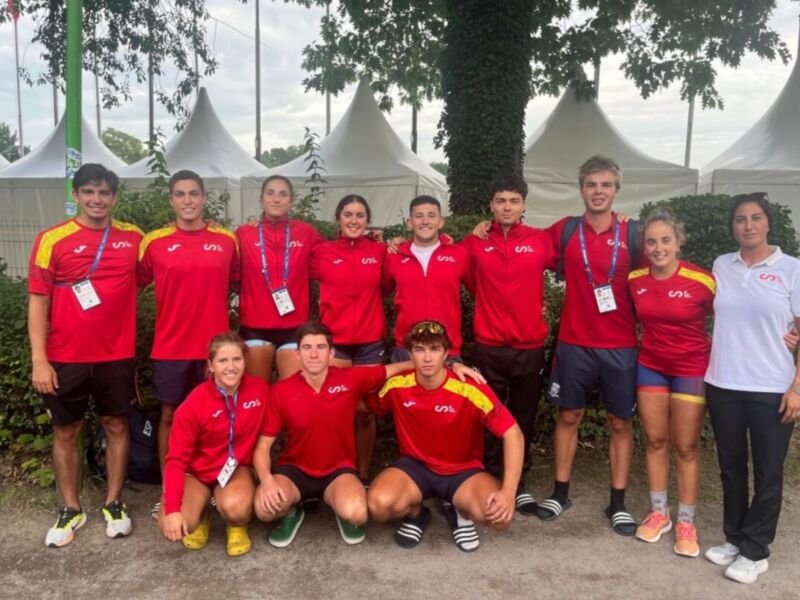 Equipo deportivo en uniforme rojo posando juntos en un evento al aire libre.