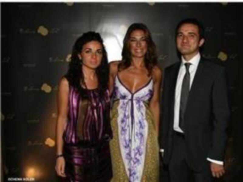 Una imagen de tres personas posando, dos de ellas son mujeres y una es hombre, todos están sonrientes y están en un evento formal. La imagen parece ser de una celebración o evento importante.
