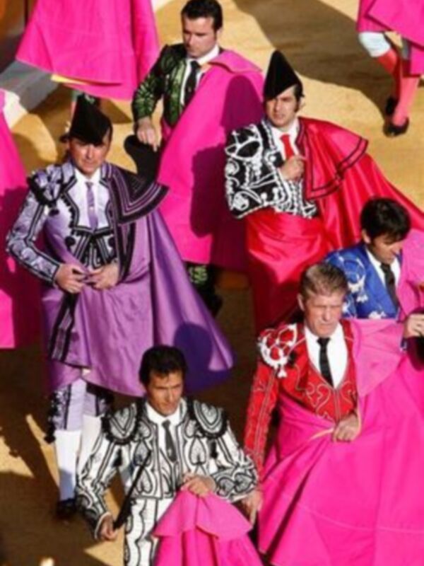 Una imagen de toreros en trajes tradicionales, incluyendo capotes y chalecos, con un fondo de color rosa y negro.