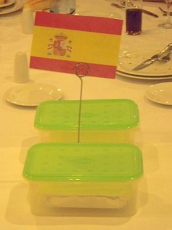 Una bandeja con una bandera española y contenedores de plástico verde.