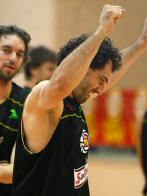 Un jugador de balonmano celebra una victoria, levantando el puño en el aire. Detalle de la camiseta con el logo de la marca 'Santander'.