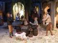 Una escena histórica con figuras antiguas en un entorno rural, posiblemente una representación de la vida cotidiana o una escena de un drama histórico.