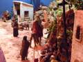 Representación de la natividad con figuras de pastores y animales en un escenario de pesebre.