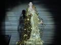 Vicky Martín Berrocal en la pasarela de Alta Costura, con un vestido dorado brillante y detalles florales.