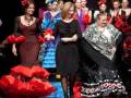 Desfile de moda flamenca con modelos luciendo vestidos tradicionales y elegantes.