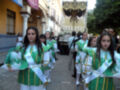 Niñas en trajes tradicionales participando en una procesión religiosa.