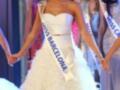 Miss Barcelona competes in a pageant wearing a white feathered gown and sash.