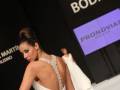 Una modelo presenta un vestido blanco con escote en la espalda durante el desfile de Pronovias en Sevilla de Boda.