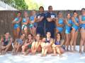Equipo de natación femenina posando en la piscina.