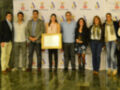 Una foto de un grupo de personas posando con un premio en una ceremonia.