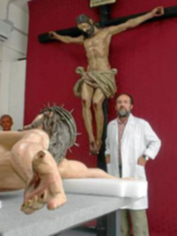 Un hombre observa una escultura de Cristo crucificado en una iglesia.