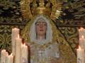 Imagen de la Virgen María con velas en una iglesia.