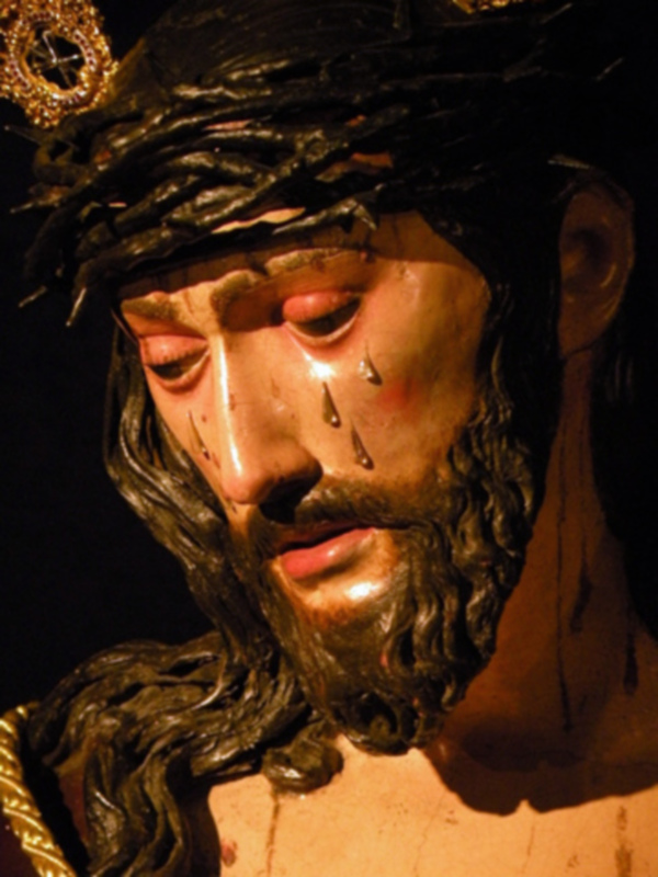 Escultura de Jesucristo con la corona de espinas, ojos cerrados y gotas de sangre.