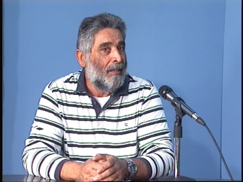 Hombre hablando en un micrófono durante una presentación o conferencia.