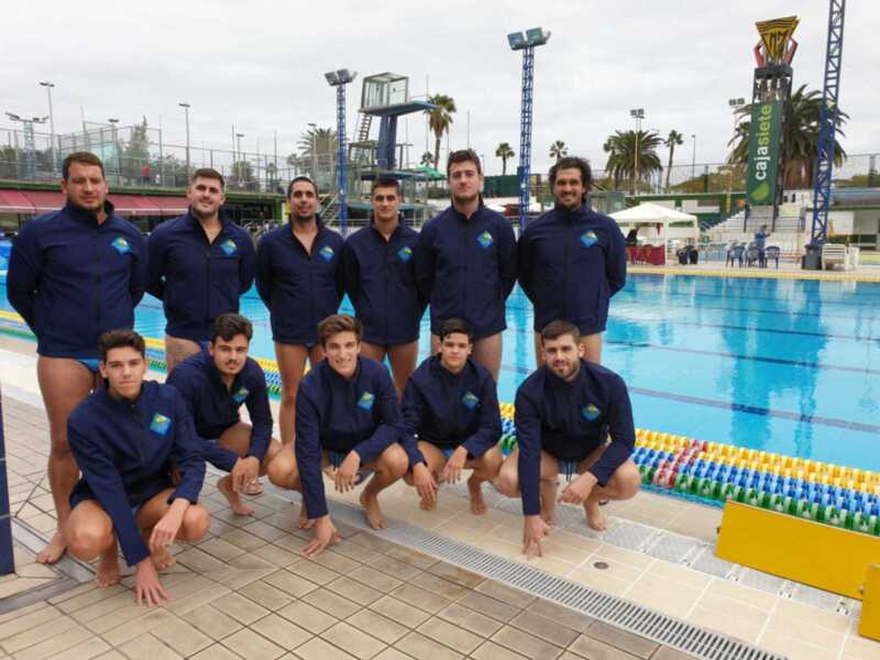 Equipo de natación masculina posando en la piscina.