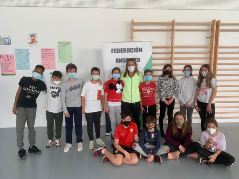Estudiantes posando en una escuela, con pancartas de la Federación Andaluza y máscaras faciales.