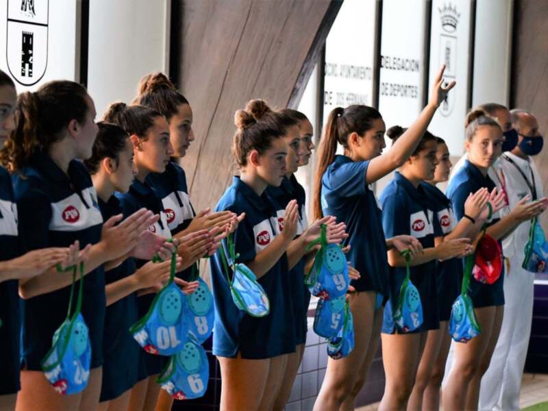 Equipo de waterpolo femenino celebrando en el banquillo.
