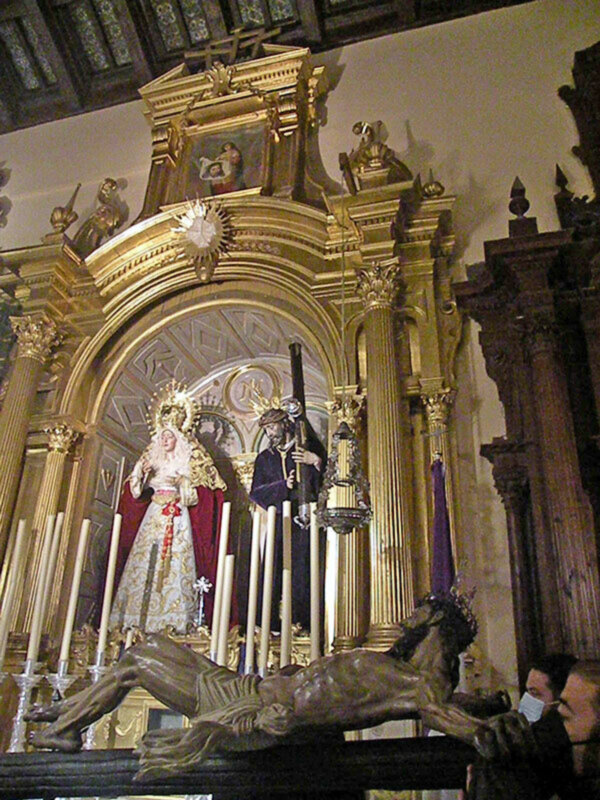 Altar de la iglesia con estatuas religiosas y candelabros.