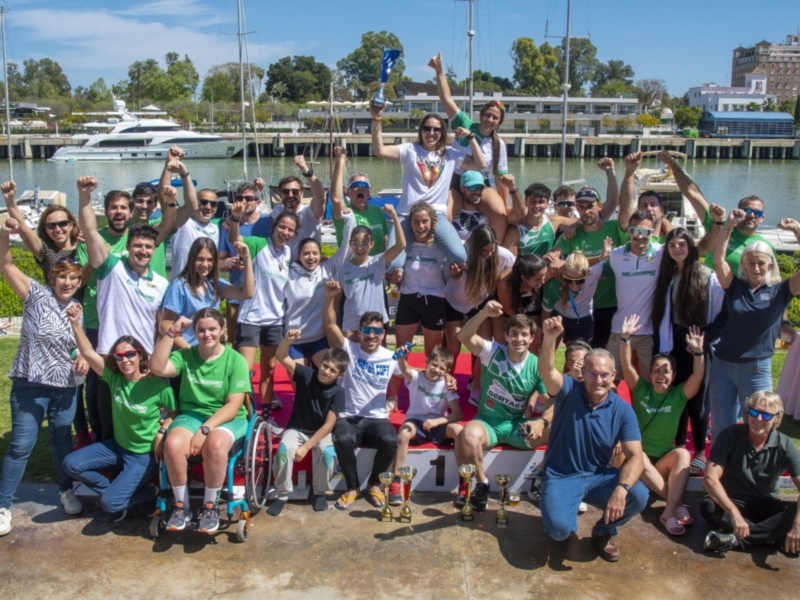 Grupo de personas con discapacidad y sin discapacidad posando juntos en un muelle, celebrando el día de la diversidad.