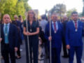 Un grupo de personas vestidas formalmente, posiblemente oficiales o representantes de algún evento importante. Se destacan por su uniformidad en trajes oscuros y accesorios como medallas y insignias. La imagen sugiere un ambiente formal o ceremonial, posiblemente relacionado con una celebración o ceremonia importante.